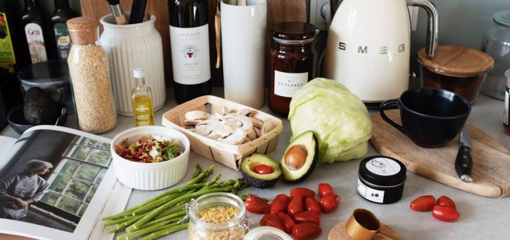 Assorted healthy food and vegetables set locating on gray countertop next to various utensils and appliances during cooking in stylish kitchen