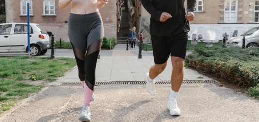 Fit couple jogging together on an urban sidewalk in sportswear.